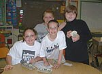 3rd and 4th grade WCCS students pose while counting money raised from the book fair